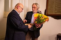 John van Tilborg neemt bloemen in ontvangst van Bert Verweij